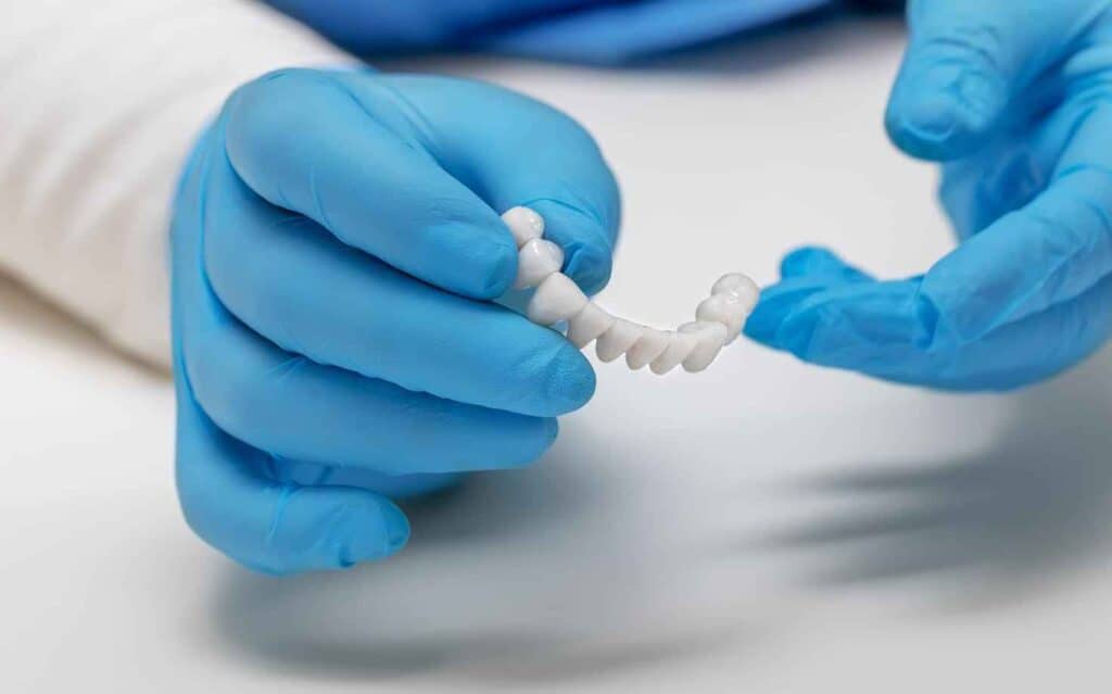 Dentist Holds Artificial Teeth by Wearing Hand Gloves | Smile Virtual
