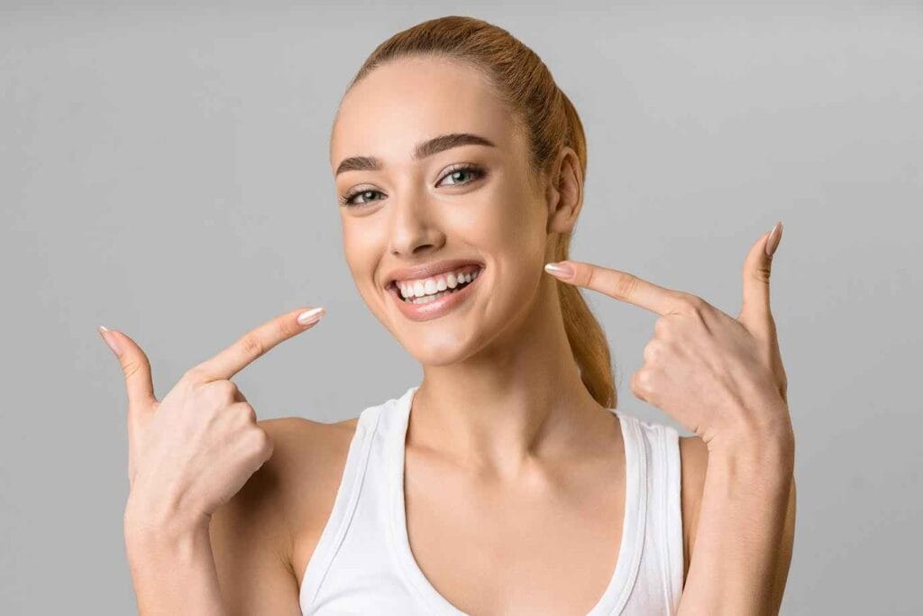 Young Girl Showing her Teeth with Pointing Fingers | Smile Virtual