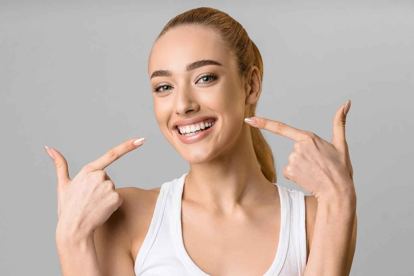 Young Girl Showing her Teeth with Pointing Fingers | Smile Virtual