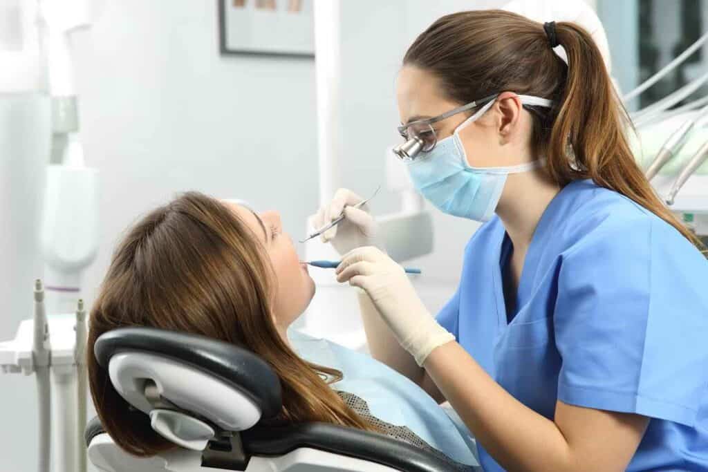 Dentist Wearing Magnifying Glasses and Treating Female Patient | Smile Virtual